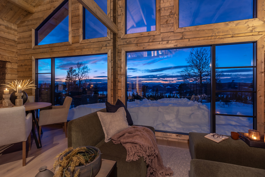 Interiør — stue med store vinduer og tømmervegger